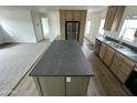 Open kitchen with a central island, stainless steel appliances, and light wood cabinets at 41735 N 260Th Ave, Morristown, AZ 85342