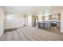 Bright open-concept living room seamlessly flows into a modern kitchen with stainless steel appliances at 41735 N 260Th Ave, Morristown, AZ 85342
