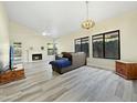 Inviting living room features a fireplace, light-colored walls, wood-look tile floors, and large windows to the backyard at 5016 E Marconi Ave, Scottsdale, AZ 85254