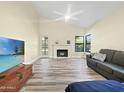 Bright living room boasts a modern fireplace, vaulted ceiling, and wood-look flooring, creating a cozy atmosphere at 5016 E Marconi Ave, Scottsdale, AZ 85254