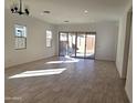 Spacious living room with tile floors and sliding glass doors to the backyard at 17586 W Blue Sky Dr, Surprise, AZ 85387