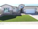 Charming single Gathering home featuring stone accents, a two-car garage, and freshly installed artificial turf at 21627 W Mariposa St, Buckeye, AZ 85396