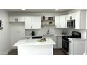 Renovated kitchen boasts white cabinets, an island, and stylish backsplash at 3733 W El Caminito Dr, Phoenix, AZ 85051