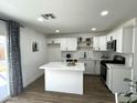 Modern white kitchen with island, stainless steel appliances, and white shaker cabinets at 3733 W El Caminito Dr, Phoenix, AZ 85051