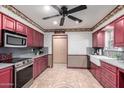 Spacious kitchen with red cabinets, stainless steel appliances, and a farmhouse sink at 6255 E Ensenada St, Mesa, AZ 85205