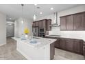 Contemporary kitchen featuring granite countertops, a stainless steel vent hood and dark cabinetry at 19341 W San Juan Ave, Litchfield Park, AZ 85340