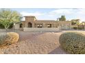 House exterior showcasing stone facade, landscaped yard, and a two-car garage at 7341 E Sutton Dr, Scottsdale, AZ 85260