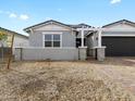 Charming single-story home with a well-manicured lawn, gray paint, and an attached two-car garage at 17703 W Southgate Ave, Goodyear, AZ 85338