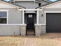 Close up view of the home's brick-paved entryway, leading to a gated entrance with a black front door at 17703 W Southgate Ave, Goodyear, AZ 85338