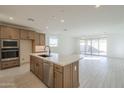 Modern kitchen with wood cabinetry, stainless steel appliances, and an island at 12028 N Luckenbach St, Surprise, AZ 85388