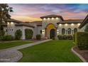 Elegant home exterior with a grand entrance and manicured lawn at 20668 E Sunset Dr, Queen Creek, AZ 85142