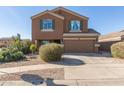 Two-story house with a tan exterior, two-car garage, and landscaping at 306 N 21St Cir, Coolidge, AZ 85128