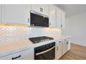 Kitchen with modern appliances, light countertops and cabinets, and stylish backsplash at 17316 W Via Dona Rd, Surprise, AZ 85387