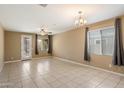 Living room with tile floors, sliding door to patio, and neutral decor at 41369 W Crane Dr, Maricopa, AZ 85138