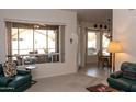 Comfortable living room featuring a large window, plush seating, and an inviting view of the outdoor patio at 8598 E Saguaro Blossom Rd, Gold Canyon, AZ 85118
