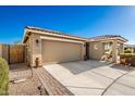 Tan house exterior with a two-car garage and desert landscaping at 1744 E 16Th Ave, Apache Junction, AZ 85119