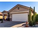 One-story home with a large garage and a tall cactus at 31627 N Poncho Ln, San Tan Valley, AZ 85143