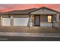 Charming single-story home with a two-car garage at sunset at 17666 W Pierson St, Goodyear, AZ 85395