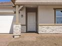 A close up view of the front door with stone accents and craftsman details at 17666 W Pierson St, Goodyear, AZ 85395