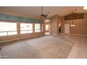 Spacious living room boasts a large window set, ceiling fan and convenient access to the kitchen at 4889 S Nighthawk Dr, Gold Canyon, AZ 85118