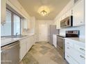 Modern kitchen with stainless steel appliances and tile floors at 9457 W Newport Dr, Sun City, AZ 85351