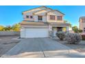 Two-story house with a white exterior, landscaping, and a two-car garage at 10350 W Alvarado Rd, Avondale, AZ 85392