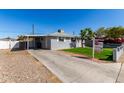 Traditional home featuring a covered carport and well-kept landscaping with a spacious driveway at 6414 W Osborn Rd, Phoenix, AZ 85033