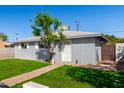 Traditional home with a gray brick exterior, white trim, and well-manicured front lawn at 6414 W Osborn Rd, Phoenix, AZ 85033