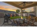 Covered patio, fire pit, grill, and grassy area at 9131 W Albert Ln, Peoria, AZ 85382