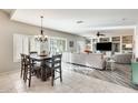 Elegant dining room adjacent to kitchen, featuring a rustic wood table and chandelier at 9131 W Albert Ln, Peoria, AZ 85382