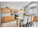 Spacious kitchen with granite countertops and light wood cabinets at 9131 W Albert Ln, Peoria, AZ 85382