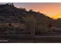 Desert landscape behind a metal fence, with beautiful sunset colors in the sky at 20436 N 17Th Pl, Phoenix, AZ 85024