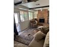 Spacious living room featuring a brick fireplace and lots of natural light at 3325 W Belmont Ave, Phoenix, AZ 85051