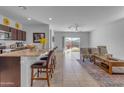 Open floor plan with kitchen island, seating, and access to the outdoor patio at 1057 W Chimes Tower Dr, Casa Grande, AZ 85122