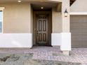 Close-up of the front door with a brick pathway, dark door, and white pillars at 17731 W Elm St, Goodyear, AZ 85395