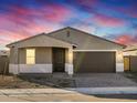 Single-story home with a two-car garage, covered porch, and brick driveway at 17731 W Elm St, Goodyear, AZ 85395