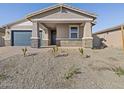 Single story home with a covered front porch, rock landscaping and a blue garage door at 4820 N 177Th Dr, Goodyear, AZ 85395