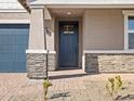 Covered front porch with stone accents on a charming single-story home at 4820 N 177Th Dr, Goodyear, AZ 85395