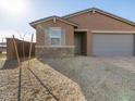 Single-story home featuring neutral stucco, gray accents, gravel landscaping, and a two-car garage at 8657 W Warner St, Tolleson, AZ 85353