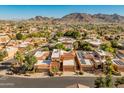 Aerial view showcasing a community of homes nestled against a mountain range at 10653 N 10Th Pl, Phoenix, AZ 85020