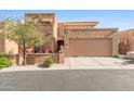 Tan stucco exterior of a two-story home with a double garage and landscaped front at 10653 N 10Th Pl, Phoenix, AZ 85020