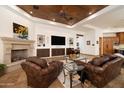 Comfortable living room with a stone fireplace, beautiful wood ceiling, and built-in media center at 33296 N Vanishing Trl, Scottsdale, AZ 85266