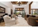 Elegant living room with high ceilings, french doors to the back yard, and sophisticated furnishings at 33296 N Vanishing Trl, Scottsdale, AZ 85266