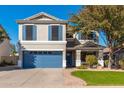 Inviting two-story home with blue accents, a well-manicured lawn, and a convenient two-car garage at 4660 E Torrey Pines Ln, Chandler, AZ 85249