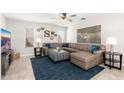 Spacious living room with plush leather sofa, stylish ottoman, ceiling fan, and an abundance of natural light at 4660 E Torrey Pines Ln, Chandler, AZ 85249