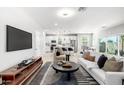 Modern living room with hardwood floors, open floor plan, white sofa, and large flat screen TV at 735 E Calavar Rd, Phoenix, AZ 85022