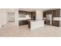 Modern kitchen with stainless steel appliances, white countertops, and an island with a sink at 25347 N 176Th Ave, Surprise, AZ 85387