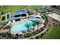 Aerial view of community pool with surrounding amenities, including a playground and tennis courts at 43429 N Wollemi St, Queen Creek, AZ 85140