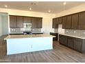 Bright kitchen features a spacious island, stainless steel appliances and modern cabinetry at 43499 N Wollemi St, Queen Creek, AZ 85140