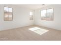 Bright bedroom with neutral carpeting, recessed lighting, and three windows at 12337 W Marguerite Ave, Avondale, AZ 85323